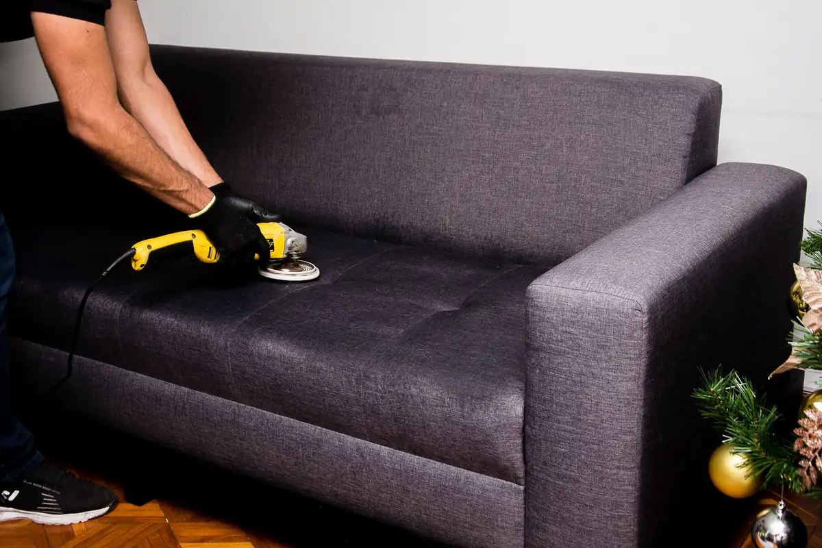 Fabric sofa cleaning | Carpet cleaning in Newcastle Dark fabric sofa being cleaned with a handheld machine, sofa cleaning in Newcastle